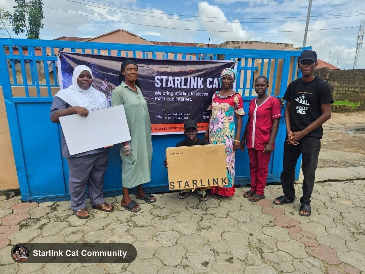 Nurses and staff of Sahel Specialist Hospital at the blue hospital gate with the Starlink kit box and the Starlink Cat banner