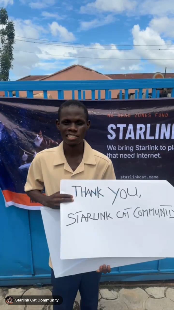 A staff member holding a sign that reads Thank you, Starlink Cat Community